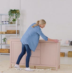 Woman sanding a cabinet