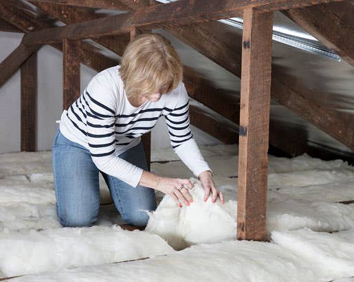 lady installing insulation in a ceiling