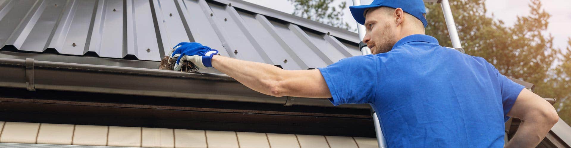  man cleaning a home gutter 